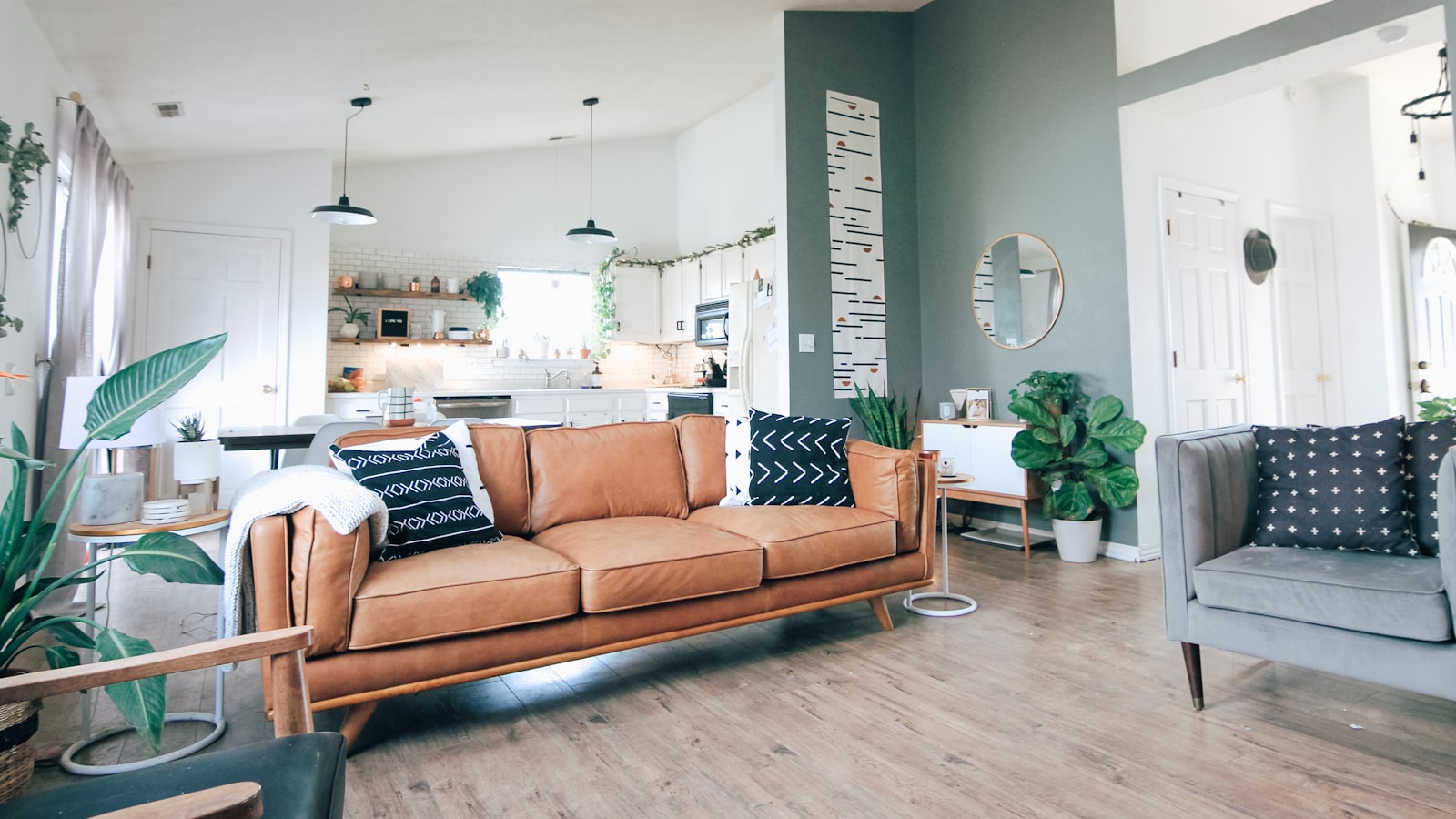 A comfortable armchair beside a window with a blanket and a small bookshelf